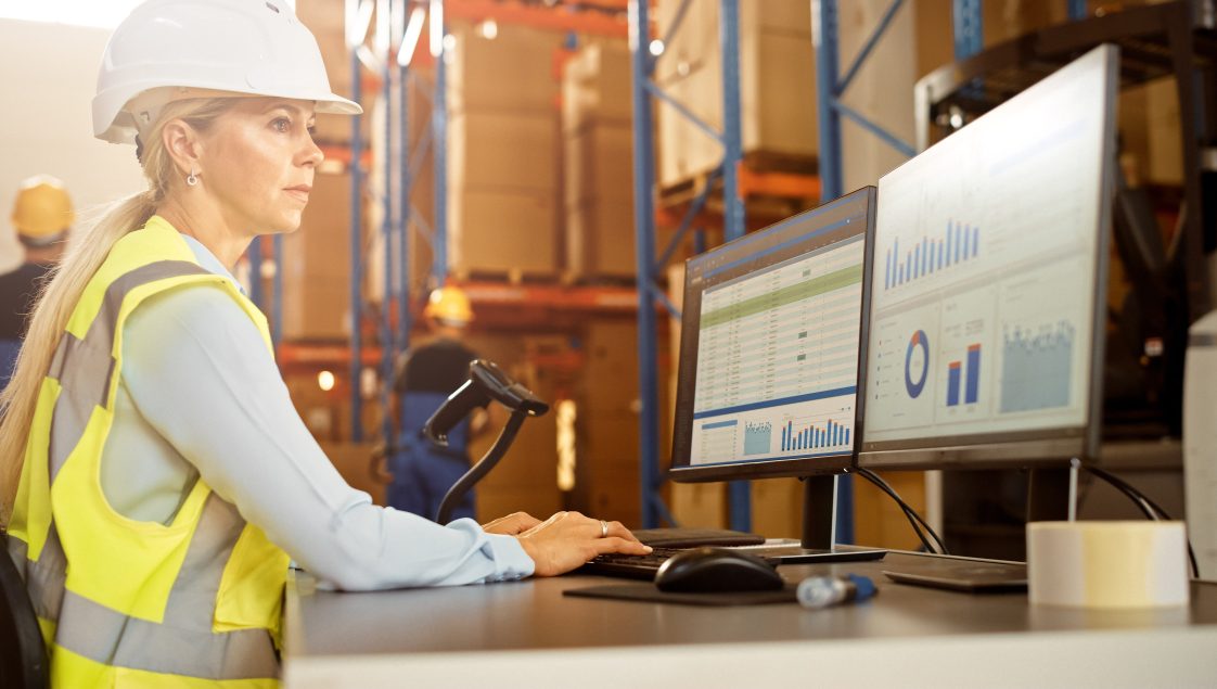 woman with hard hat working on computer
