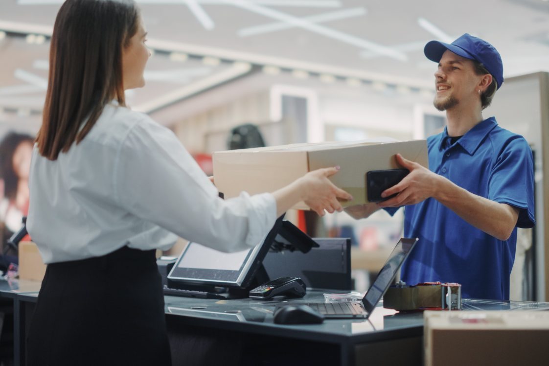 woman handing package to clerk at packaging store