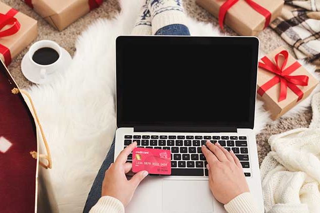 person christmas shopping on computer with credit card