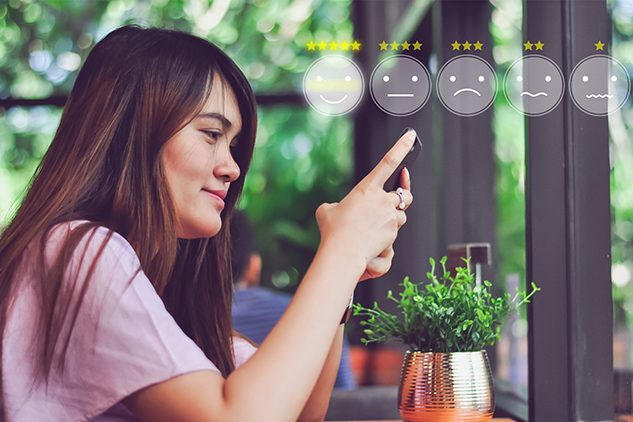 woman on phone with smiley face icons