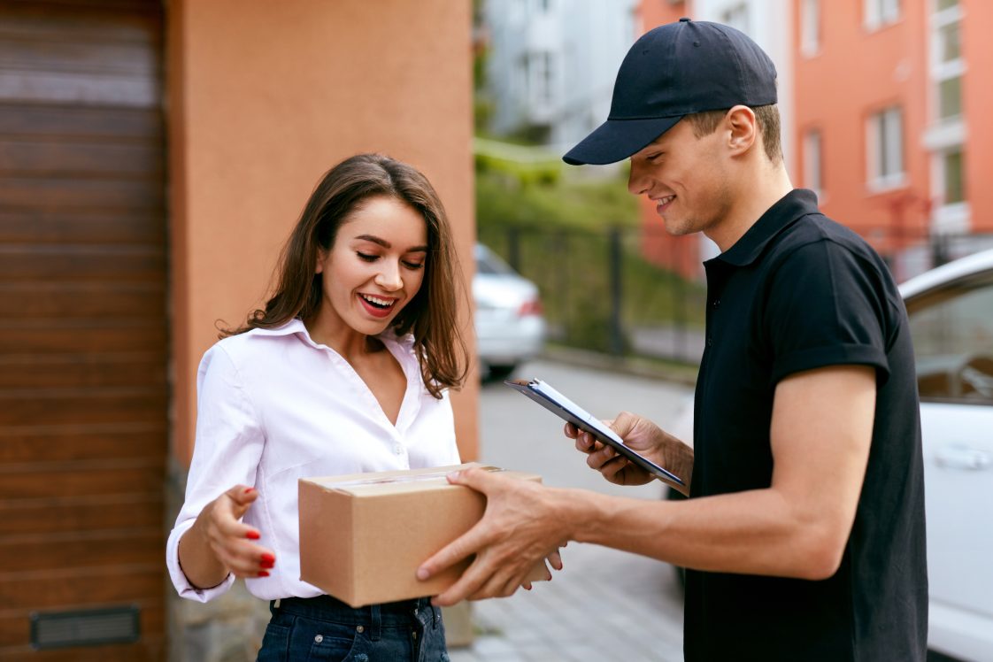 woman getting package from delivery driver