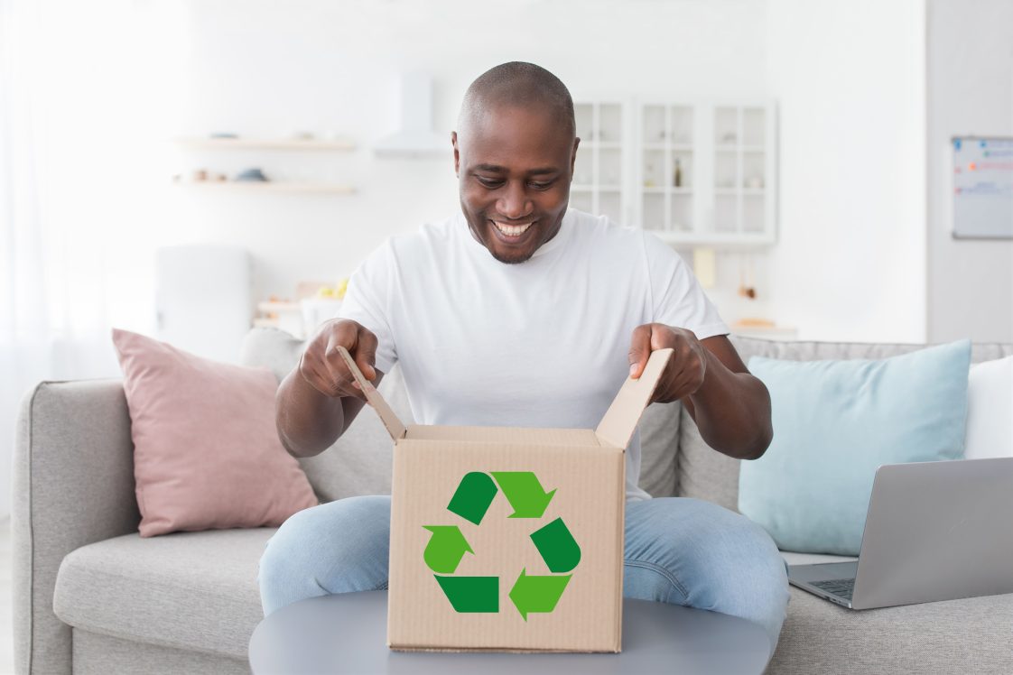 smiling man opening a box made from recycled cardboard
