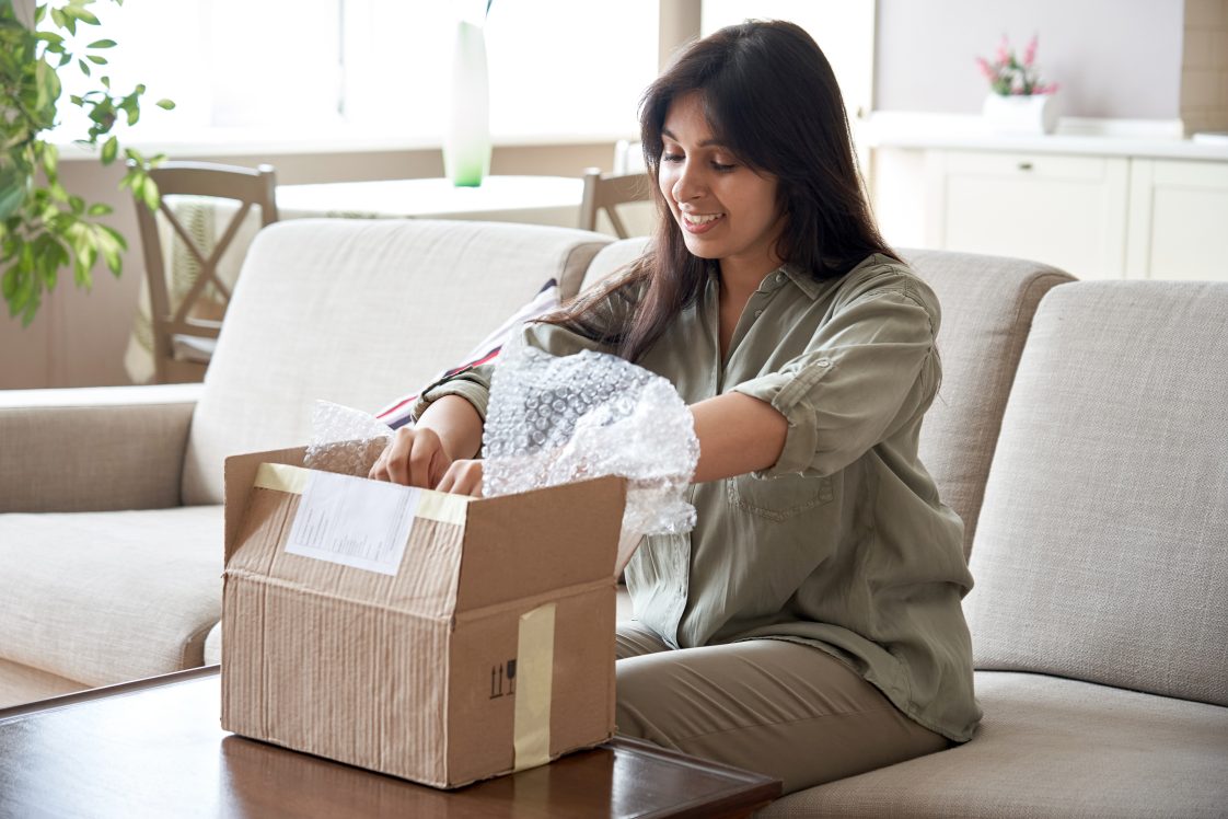 smiling young woman opening a package