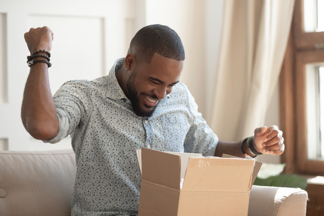 happy african american man opening up a package