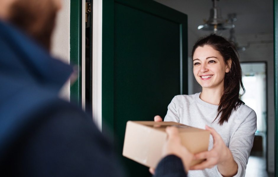 happy woman receiving a package from delivery driver