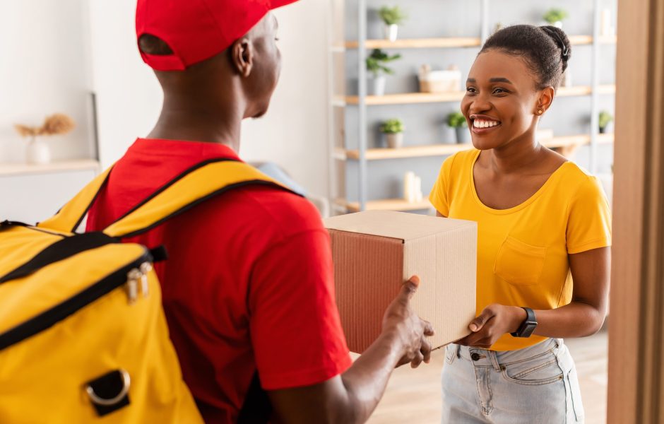 man delivering box to smiling woman at the door