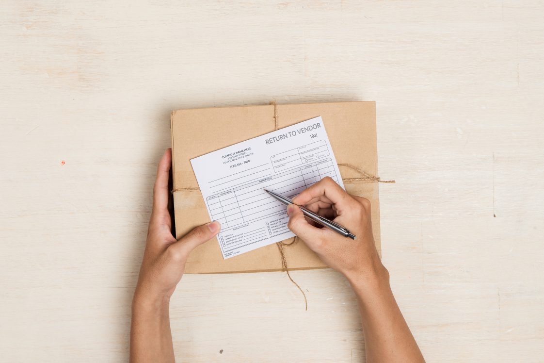 person with box filling out return slip