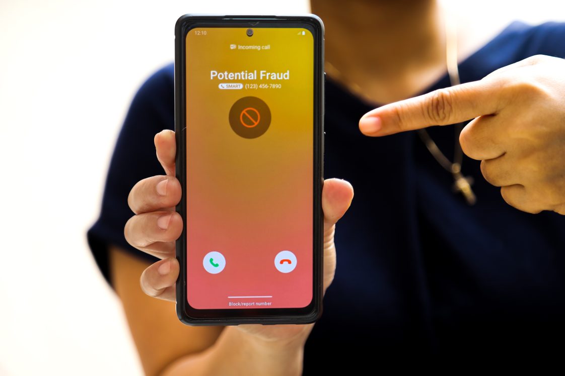 person holding phone with fraud alert