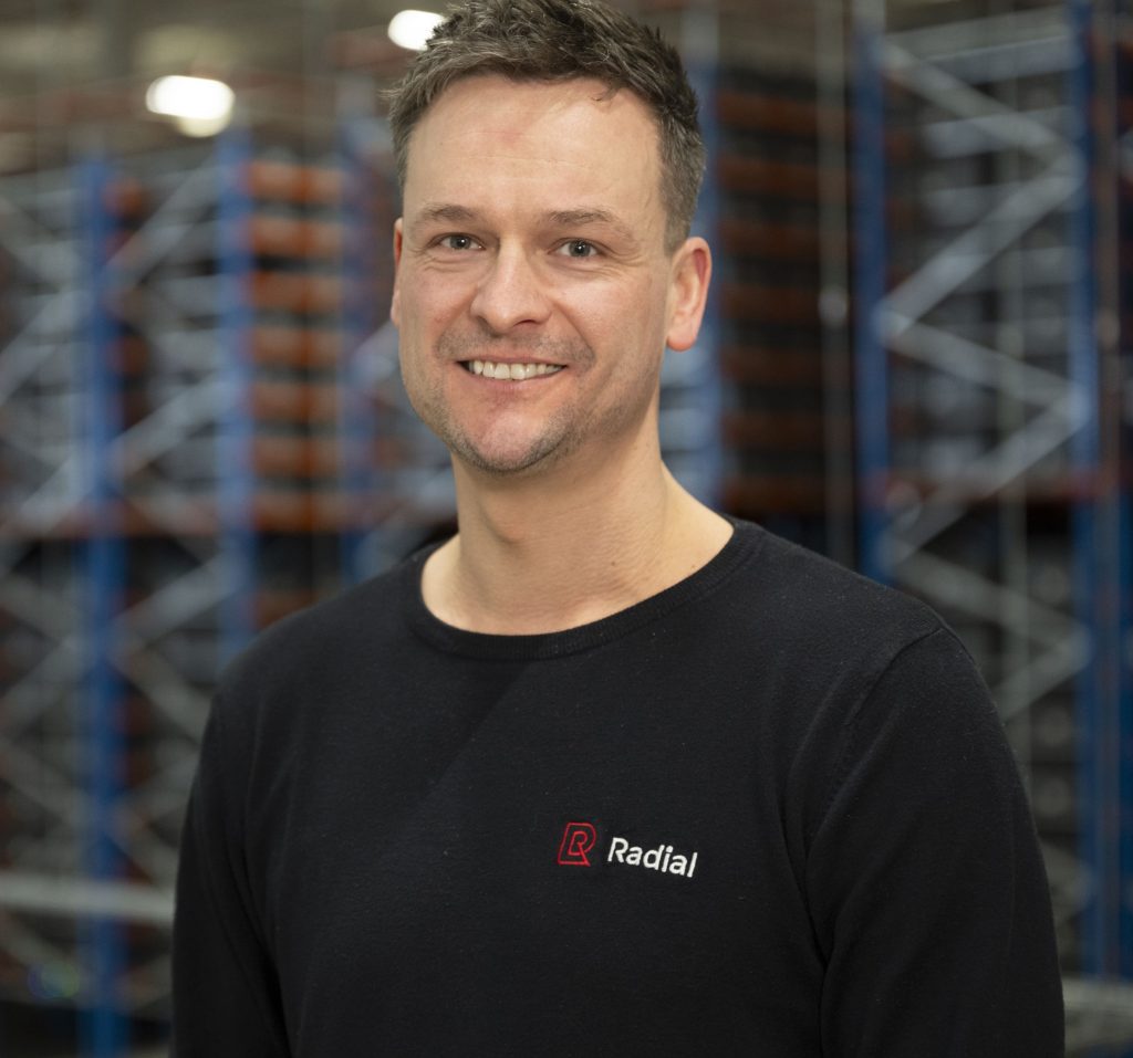 Ruben Tiben in a black shirt standing in Radial's distribution warehouse in Groningen