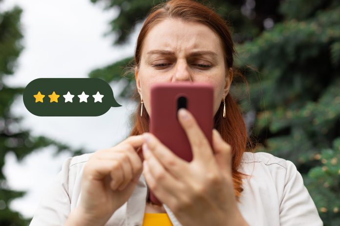woman on phone giving two star rating on a purchase