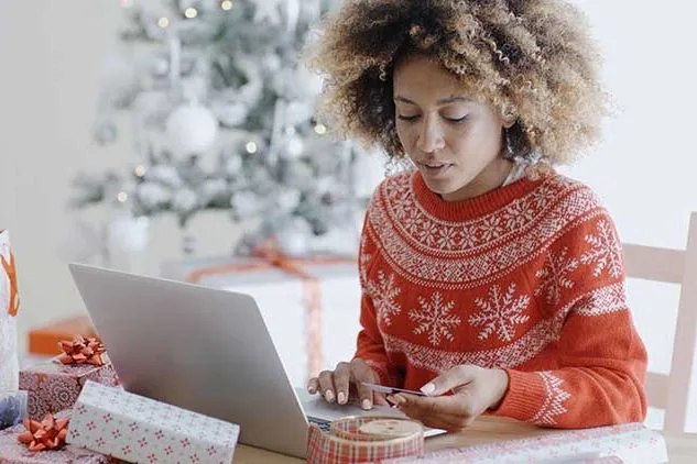 lady in christmas sweater at computer