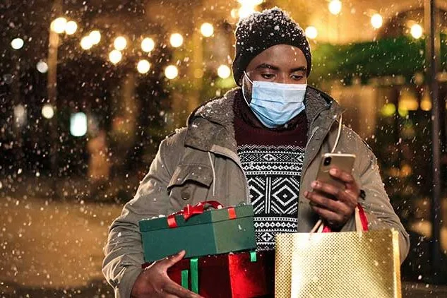 man holding holiday shopping bags