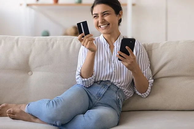 woman on couch shopping on phone