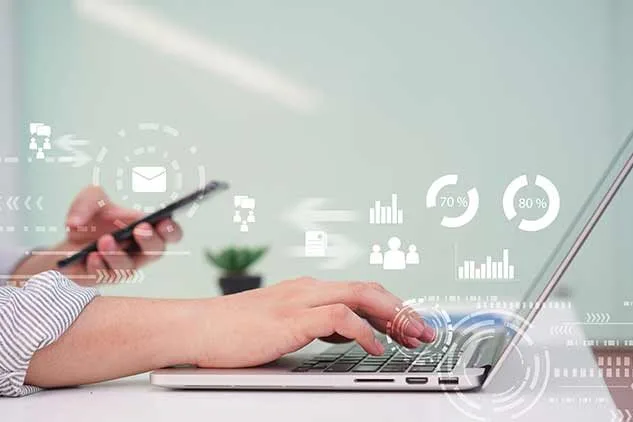 woman on laptop looking at phone