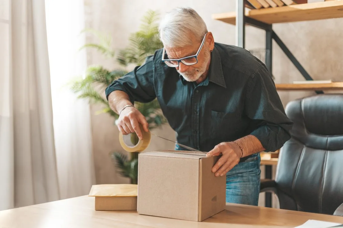 man taping a box shut