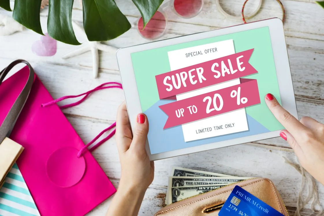 person looking at tablet with an advertisement for a sale