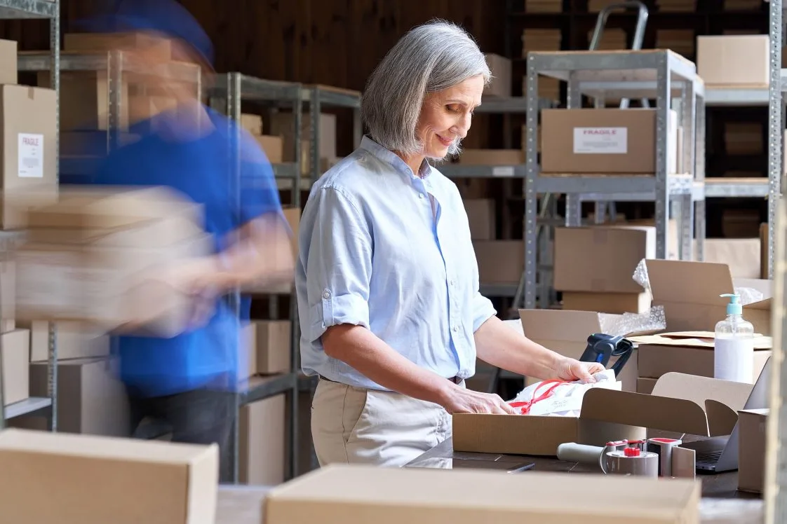 woman boxing a package in fulfillment center