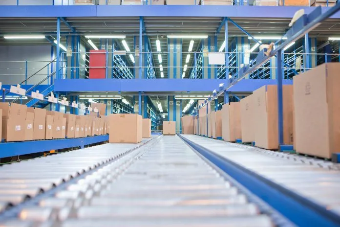 Low-angle shot of boxes placed on a conveyor belt at a distribution warehouse.